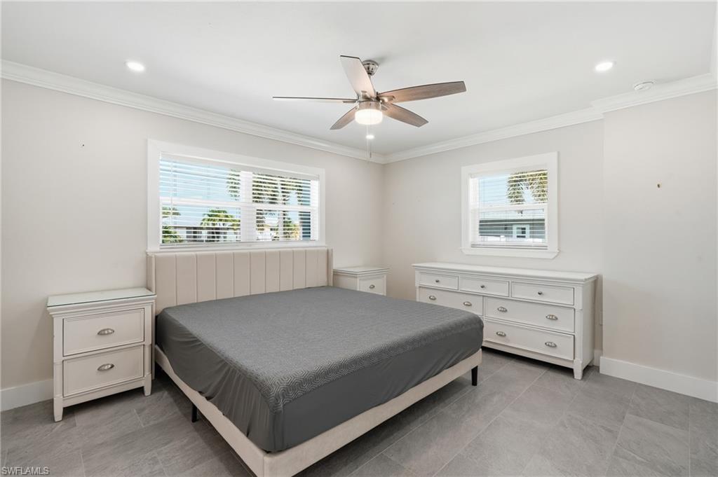 Spacious room featuring tile flooring, crown molding, recessed lighting, and a ceiling fan with light fixture