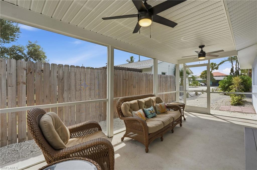 Screened patio featuring a solid ceiling with two ceiling fans, concrete flooring, and a privacy fence