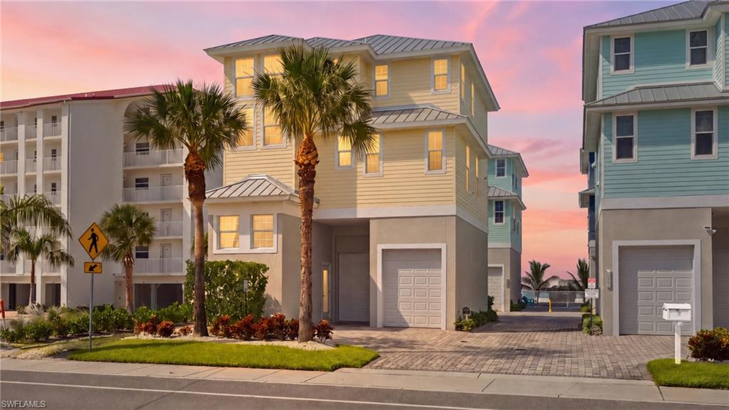 Modern coastal residence featuring a striking cream and black exterior with metal roof accents, flanked by mature palm trees - Virtually Edited Image