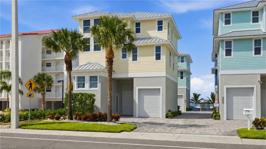 Modern coastal residence featuring a striking cream and black exterior with metal roof accents, flanked by mature palm trees - Virtually Edited Image