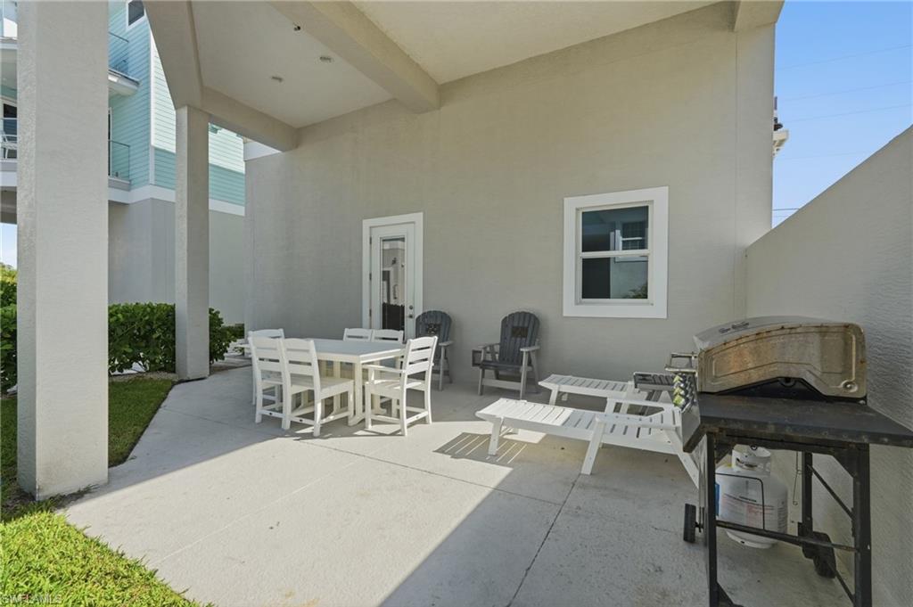 Covered outdoor patio with smooth concrete flooring and a stucco exterior - Virtually Edited Image