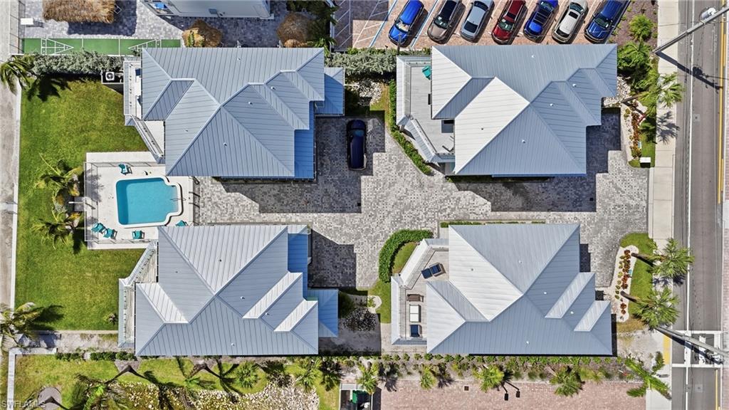 Four properties with gray metal roofs, paver driveways, and landscaped grounds - Virtually Edited Image