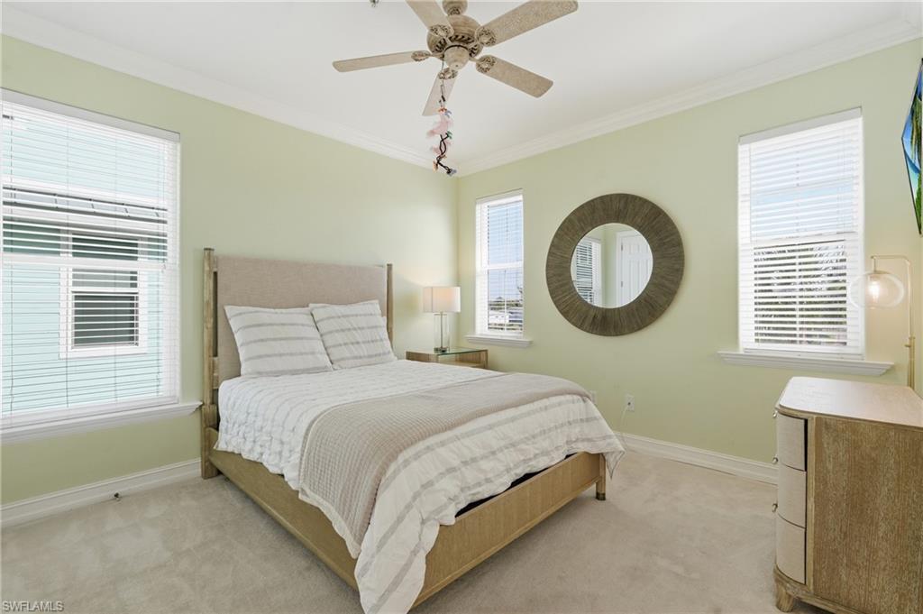Tray ceiling with a ceiling fan, crown molding, and light green painted walls - Virtually Edited Image