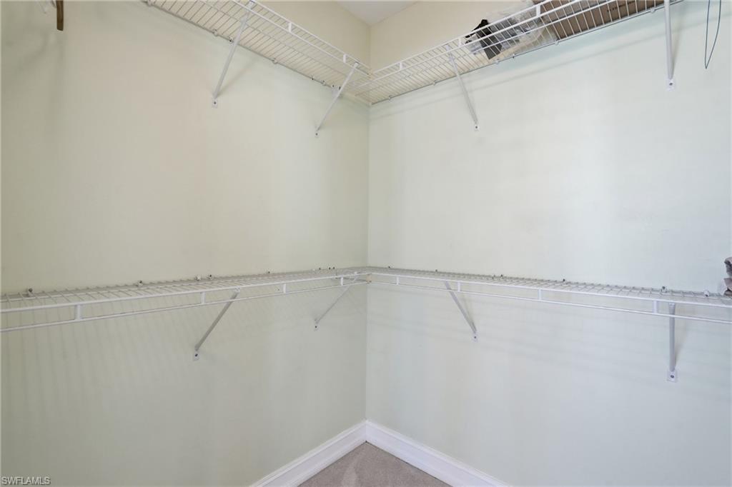Walk-in closet with wire shelving and wall-mounted hanging rods - Virtually Edited Image