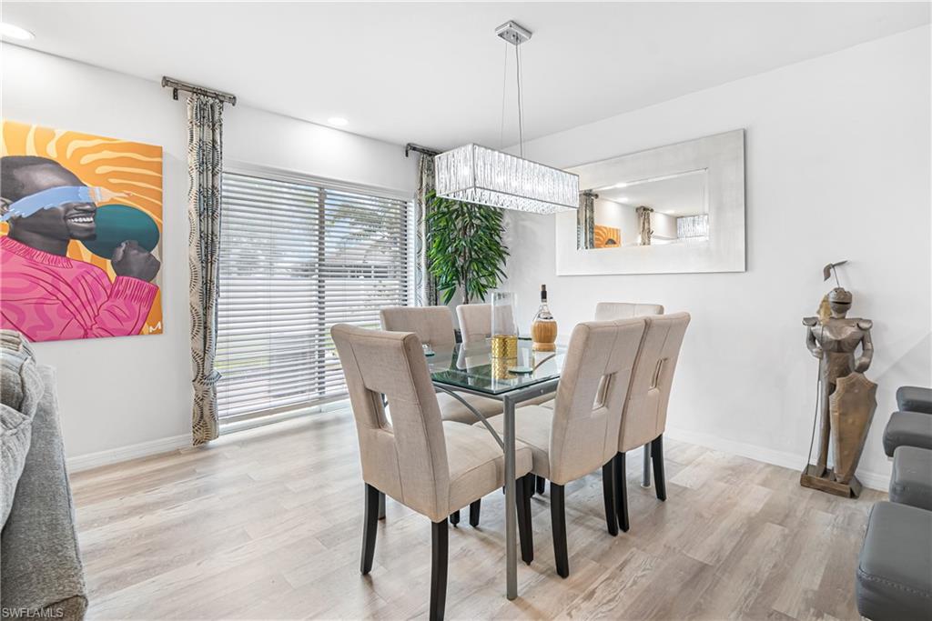 Dining area featuring light wood-finish flooring, a contemporary rectangular chandelier, and a large sliding glass door
