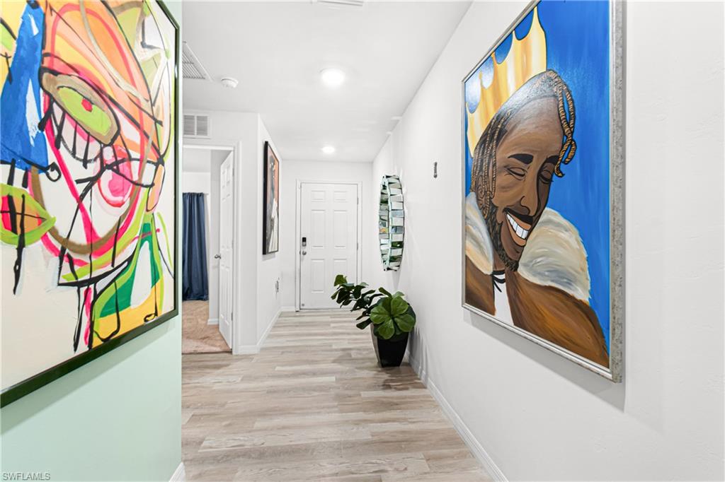 Hallway featuring wood-finish flooring, recessed lighting, and a paneled entry door