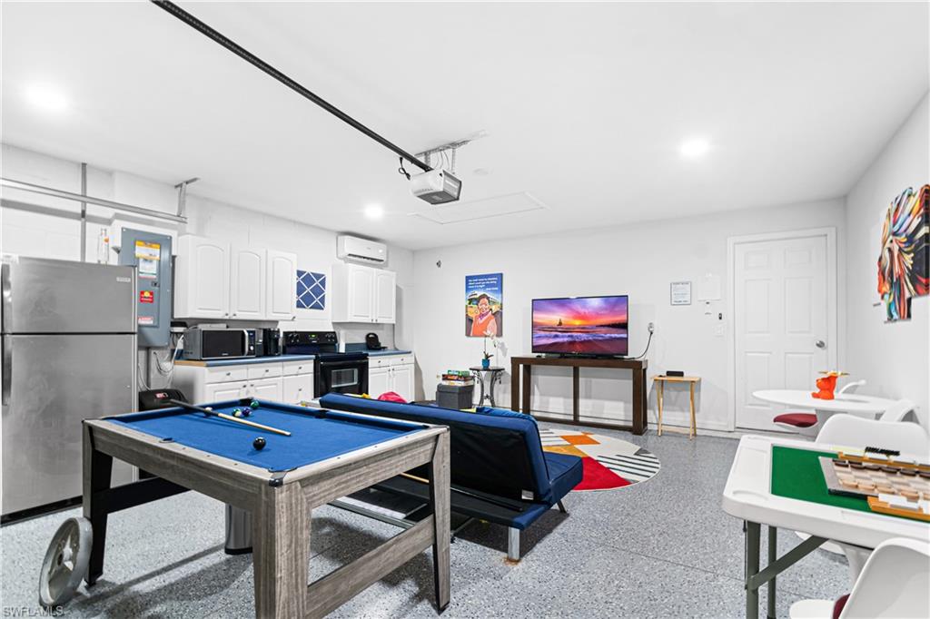 Versatile bonus room featuring a speckled epoxy floor, a wall-mounted mini-split HVAC unit, and recessed lighting