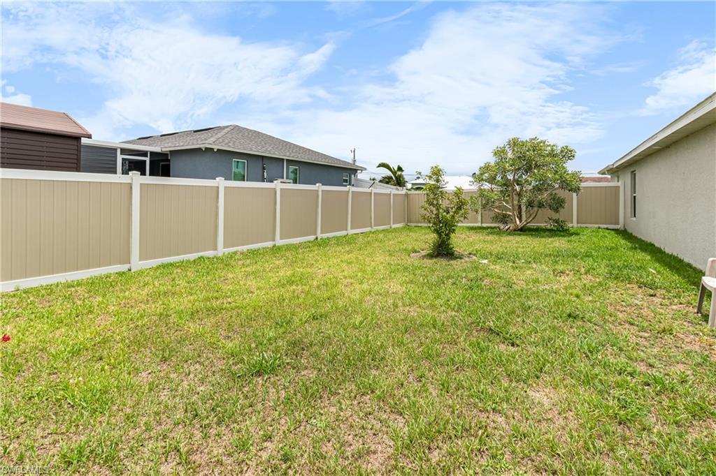Fenced backyard with mature trees and ample green space