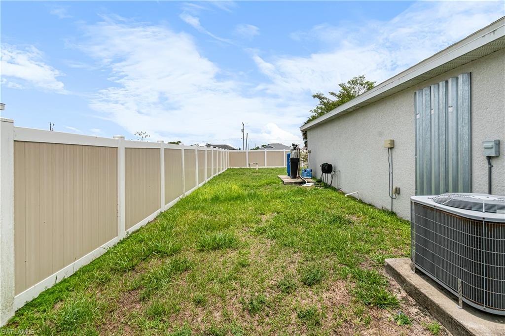 Spacious backyard featuring a full-height privacy fence and an external HVAC unit