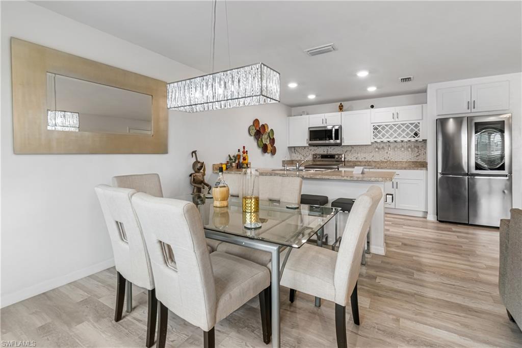 Integrated kitchen and dining area featuring light wood-finish flooring