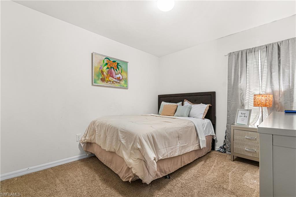 Bedroom with light-toned carpet flooring and white painted walls