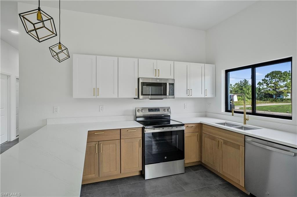 Modern kitchen featuring white upper cabinetry, wood-finish lower cabinetry, and light-toned countertops