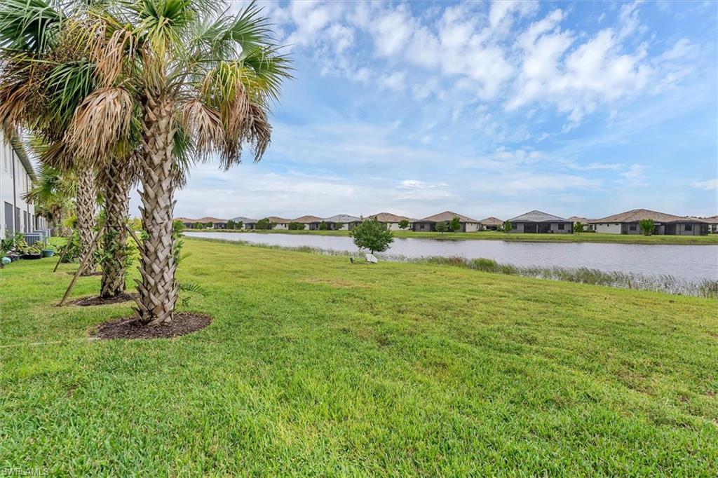 View of green lawn with a residential view and a water view
