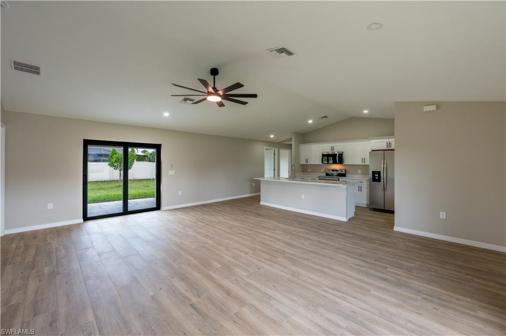 Open-concept living area with wood-finish flooring, recessed lighting, and a ceiling fan