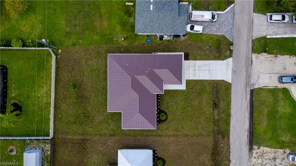 Property featuring a geometric roof, concrete driveway, and landscaped perimeter