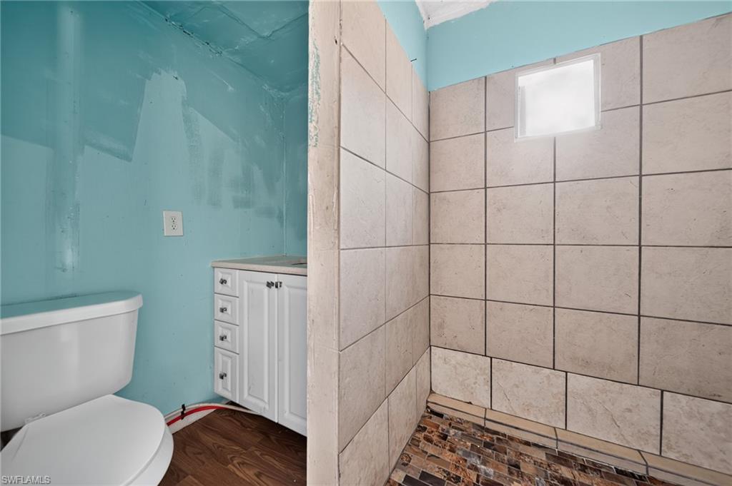 Shower enclosure featuring large format wall tiles and a mosaic tile floor