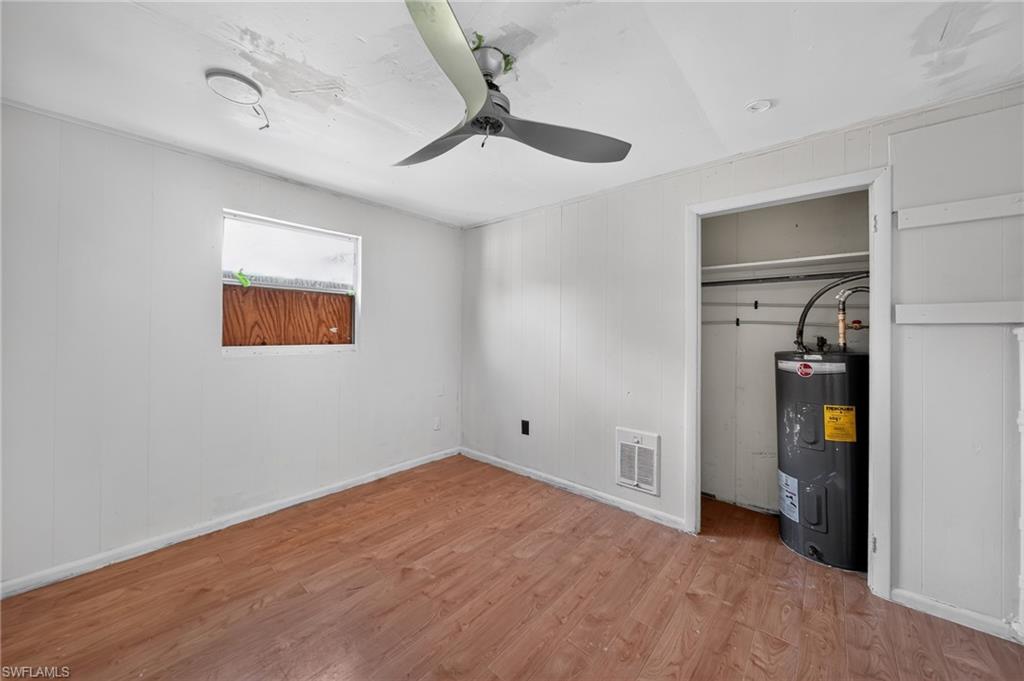 Room featuring wood-finish flooring, white paneled walls, and a recessed ceiling light