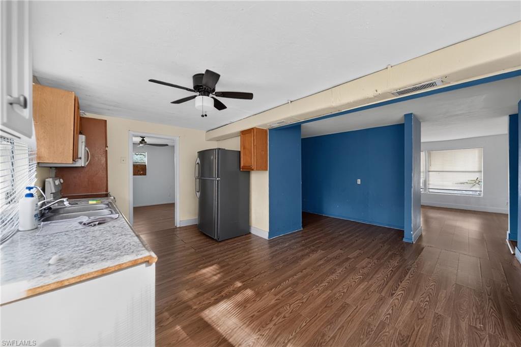 Kitchen area featuring wood-finish flooring, a ceiling fan, and a stainless steel refrigerator