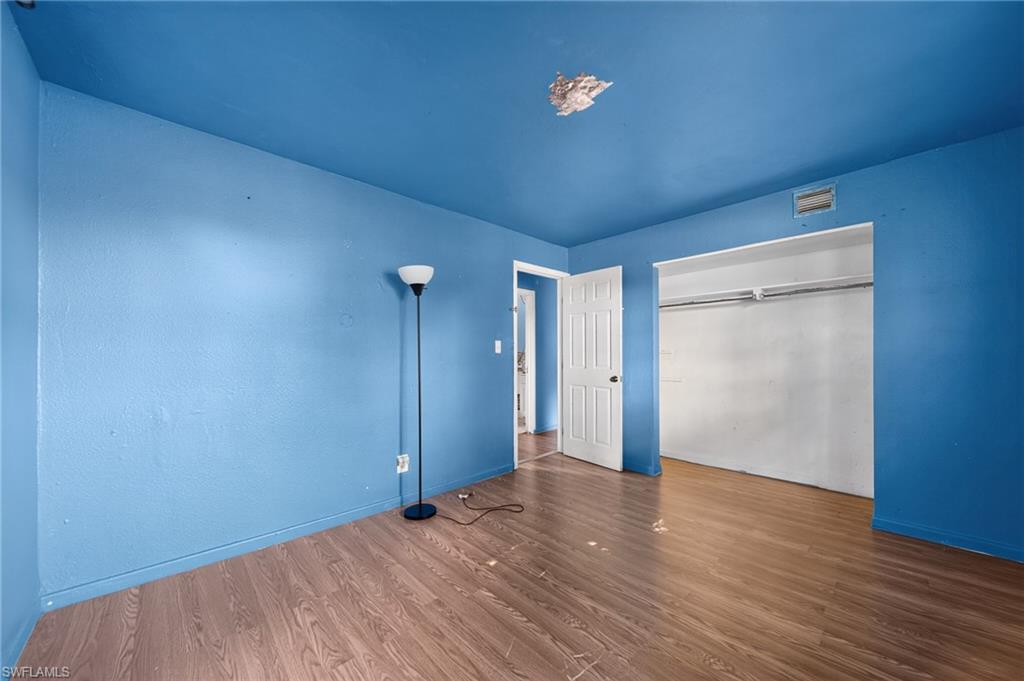 Room featuring wood-finish flooring and a vibrant blue wall and ceiling finish