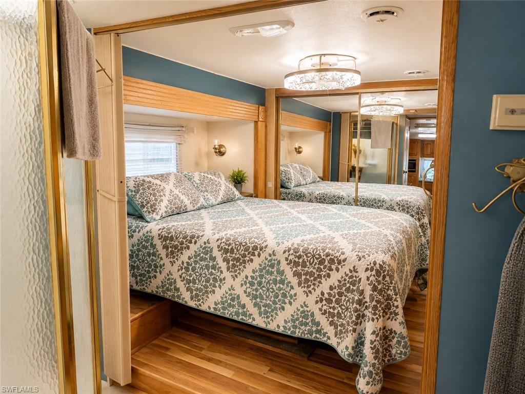 Wood-finish flooring, built-in storage with wood trim, and a ceiling-mounted lighting fixture