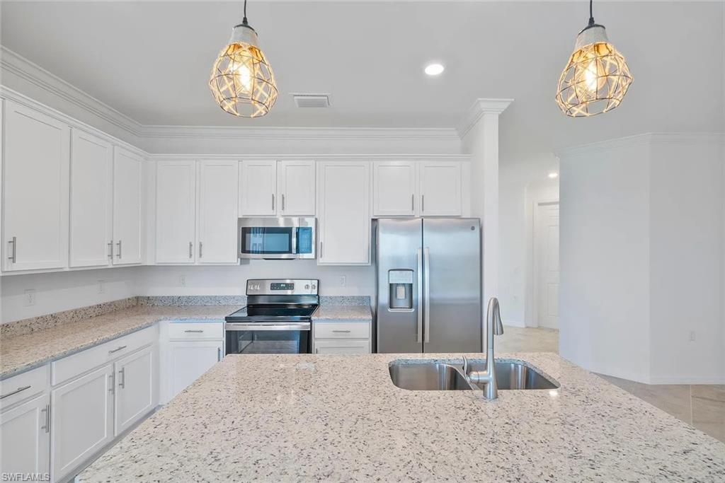 Spacious kitchen featuring an expansive island with an undermount double-bowl sink and gooseneck faucet