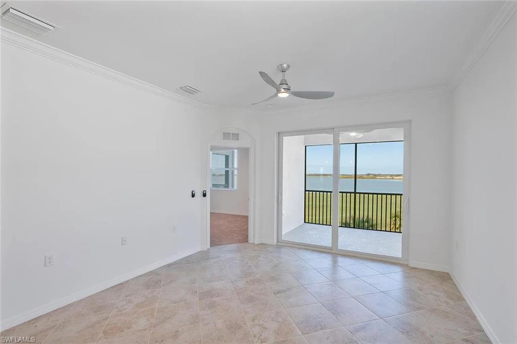 Spacious interior room featuring tile flooring and crown molding