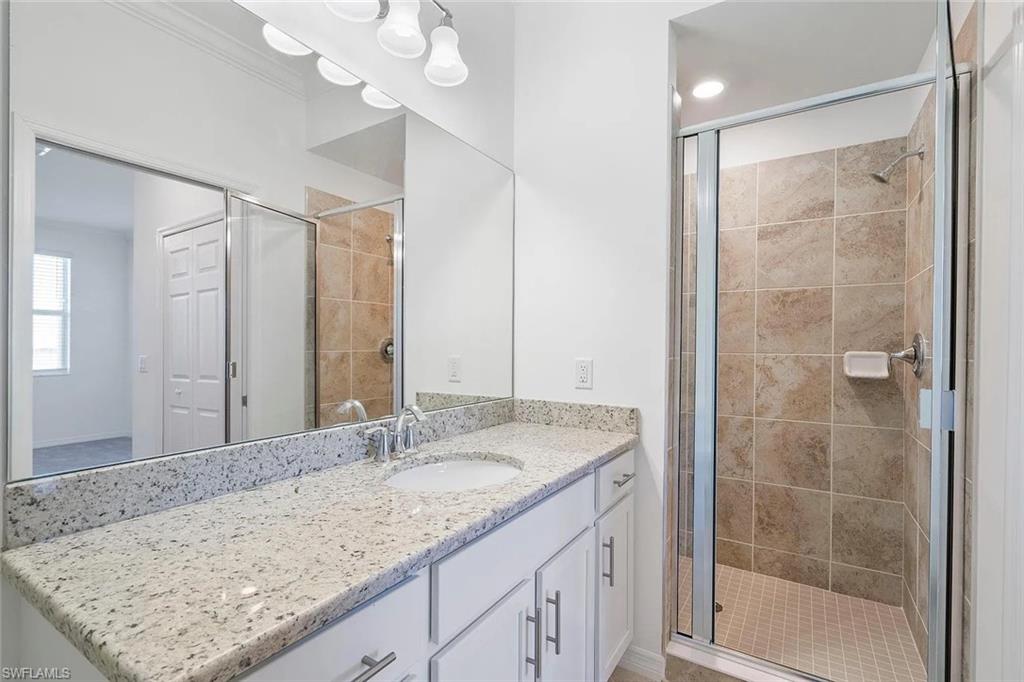 Bathroom featuring a shower with glass enclosure, tiled walls, and a tiled floor