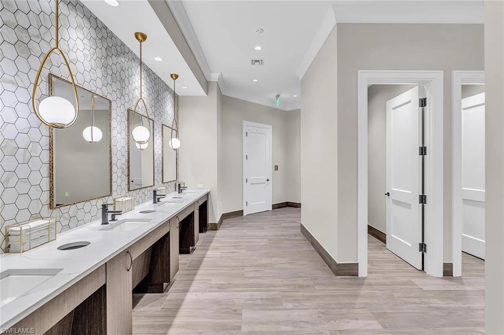 Vanity area featuring a continuous white countertop with multiple sinks, matte black faucets, and large rectangular mirrors