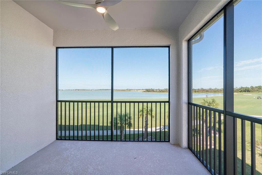 Screened balcony featuring a ceiling fan and water scenery