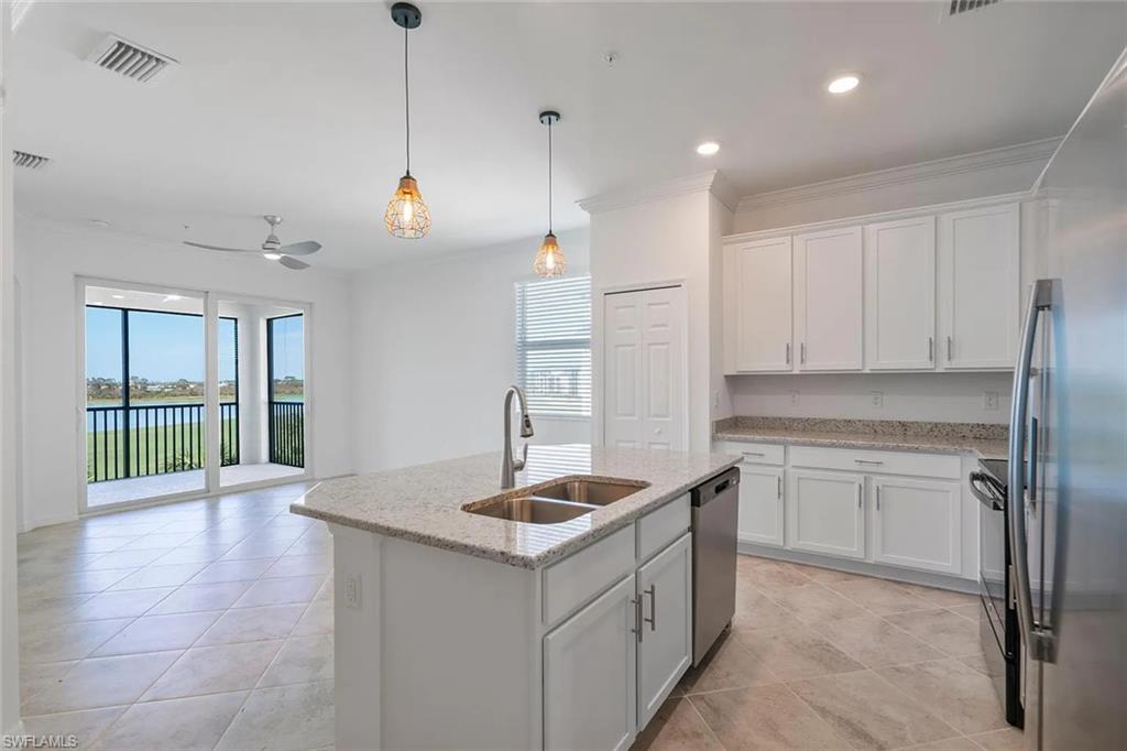 Kitchen island featuring a double-basin sink and stainless steel appliances