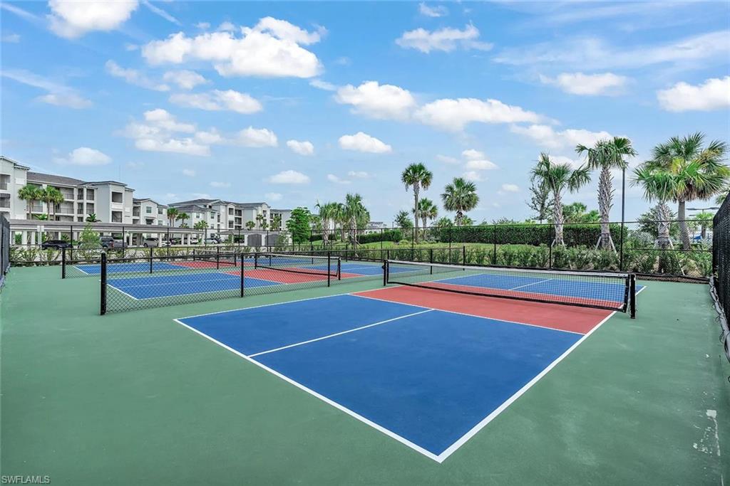 Multiple pickleball courts featuring blue and red playing surfaces with white boundary lines