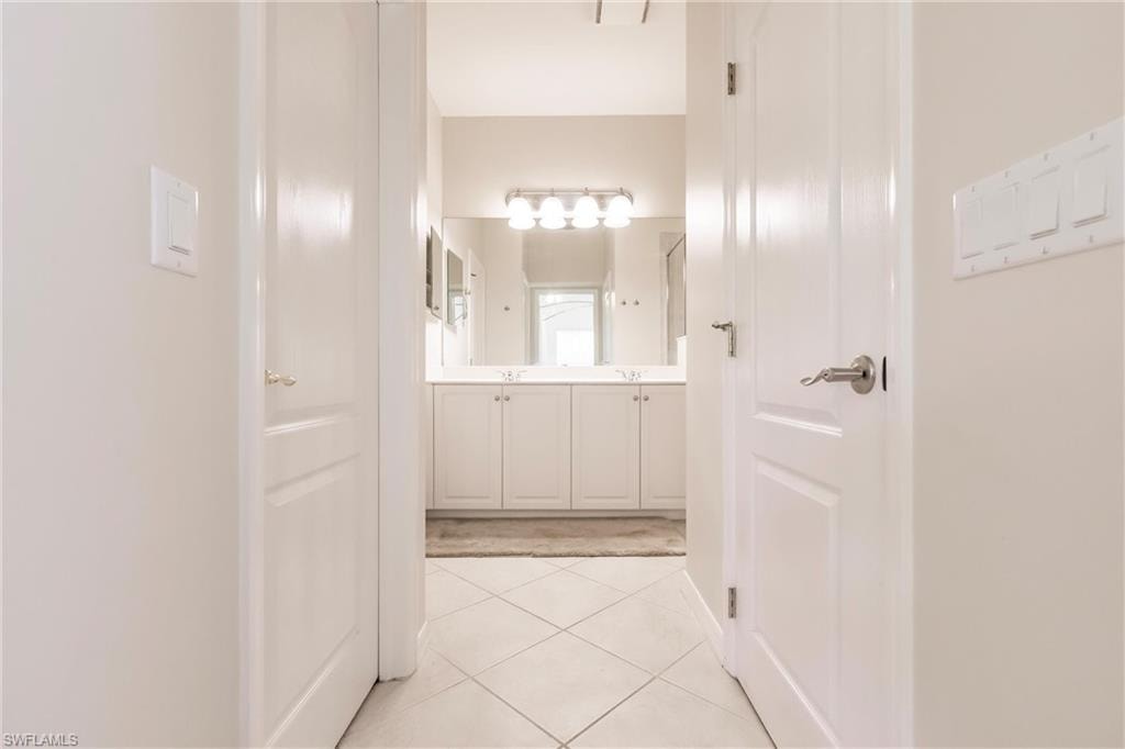 Full bathroom featuring double vanity and light tile patterned floors