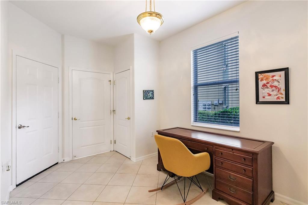 Home office with light tile patterned floors and baseboards