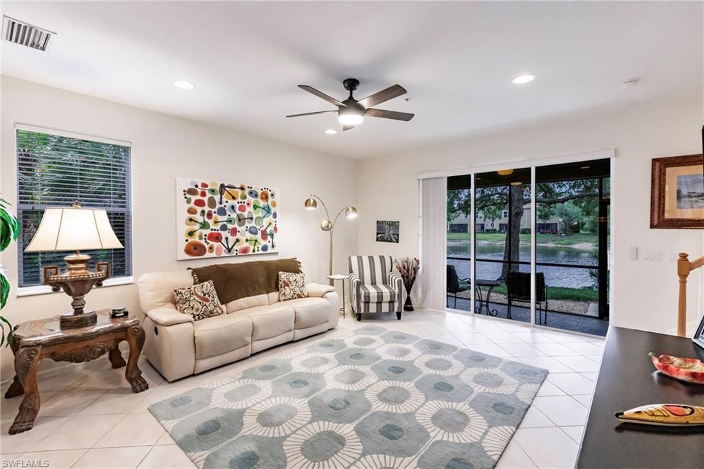 Living area with a ceiling fan, a water view, light tile patterned floors, and recessed lighting