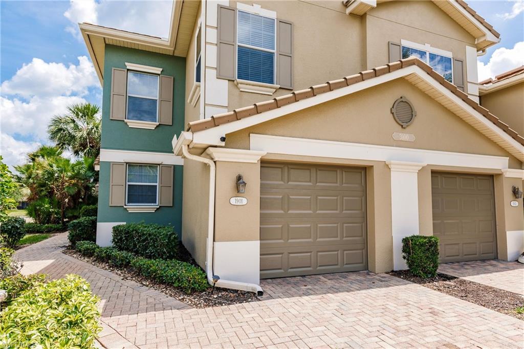 View of front of house with stucco siding and decorative driveway