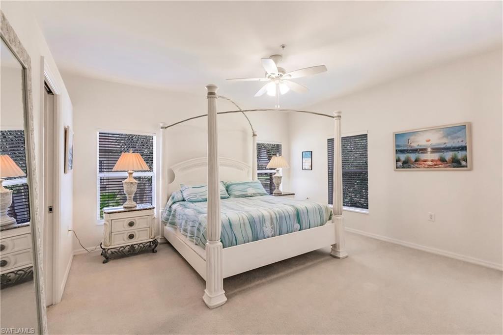 Bedroom with ceiling fan and light carpet