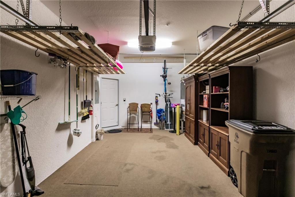 Garage with a textured wall and a garage door opener