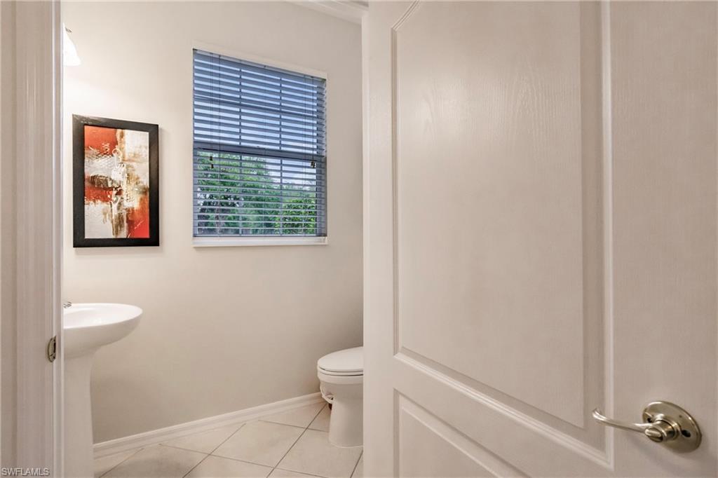 Half bathroom featuring toilet and light tile patterned floors