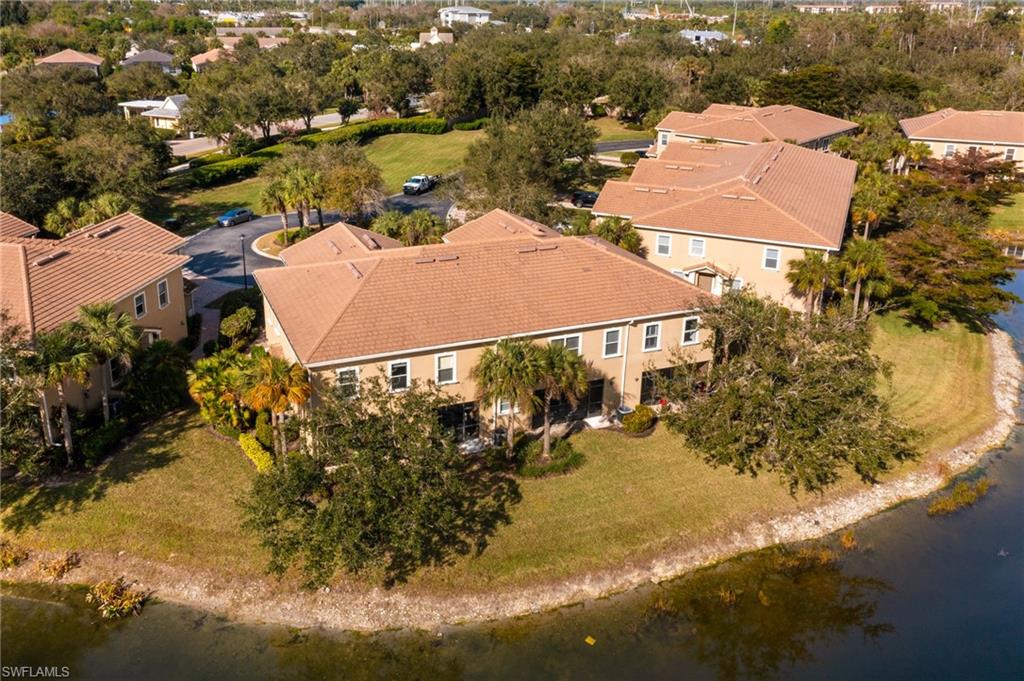 Aerial view of residential area with a large body of water and a tree filled landscape