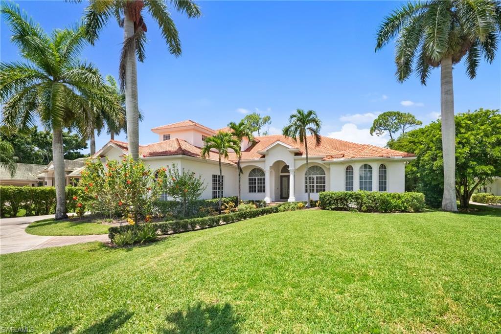 Mediterranean-style architecture with a tile roof, arched windows, and a prominent entryway