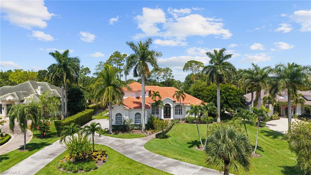 Mediterranean-inspired residence featuring a terracotta-tiled roof and white stucco exterior