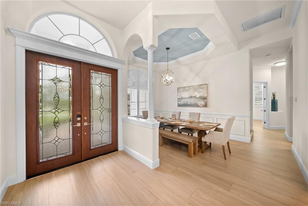 Double entry doors with decorative glass panels and an arched transom window