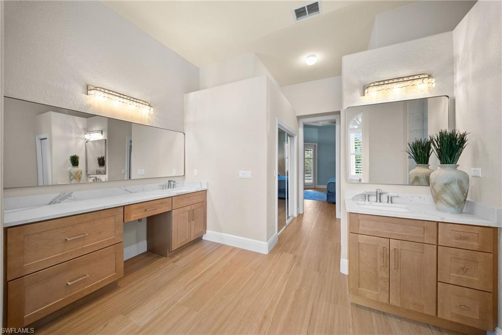 Dual wood-finish vanities with white countertops and rectangular sinks