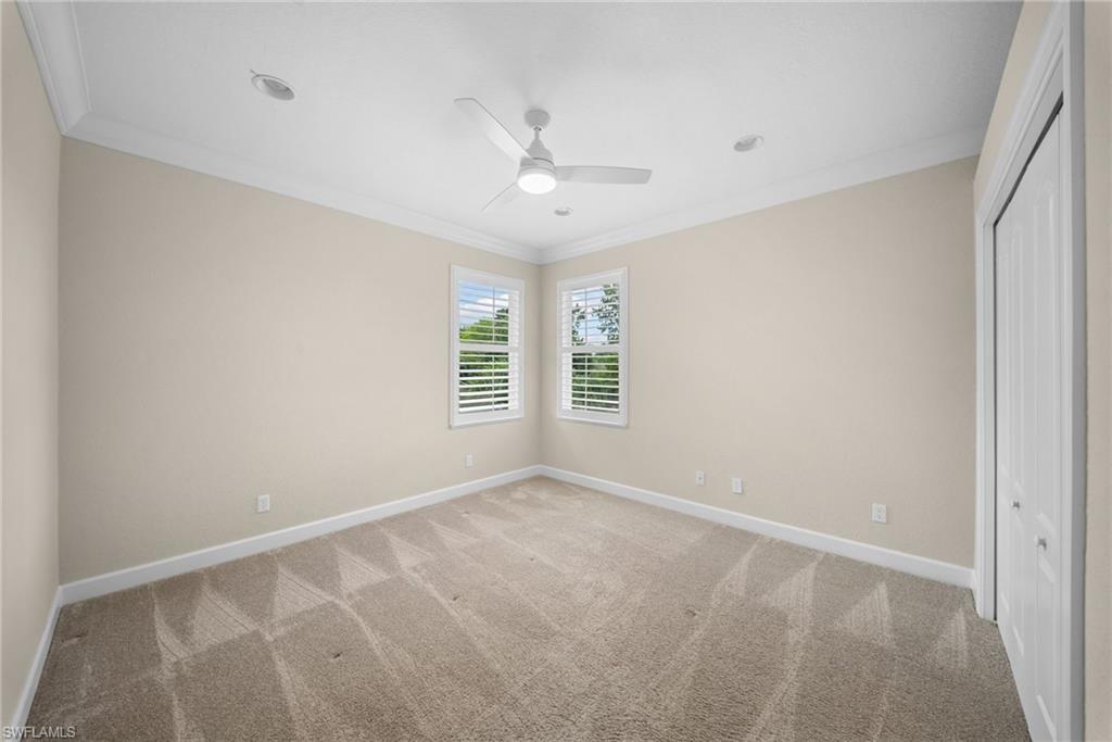 Spacious room featuring neutral-toned walls, recessed lighting, and crown molding
