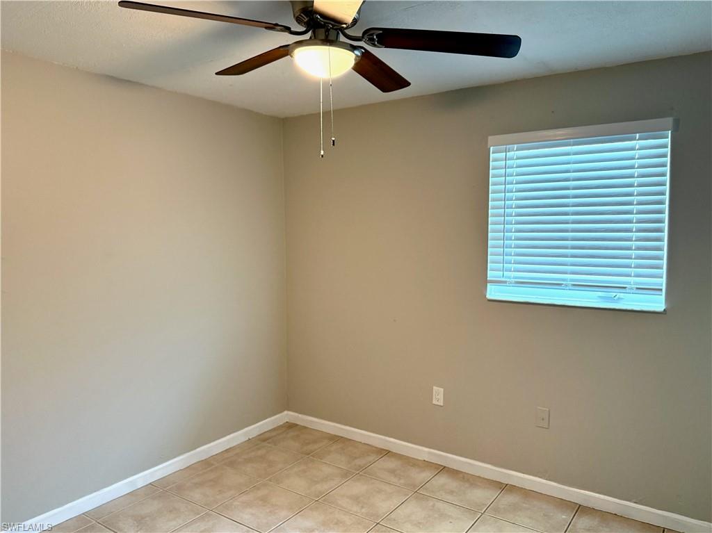 Room featuring neutral wall tones, square tile flooring, and white baseboards