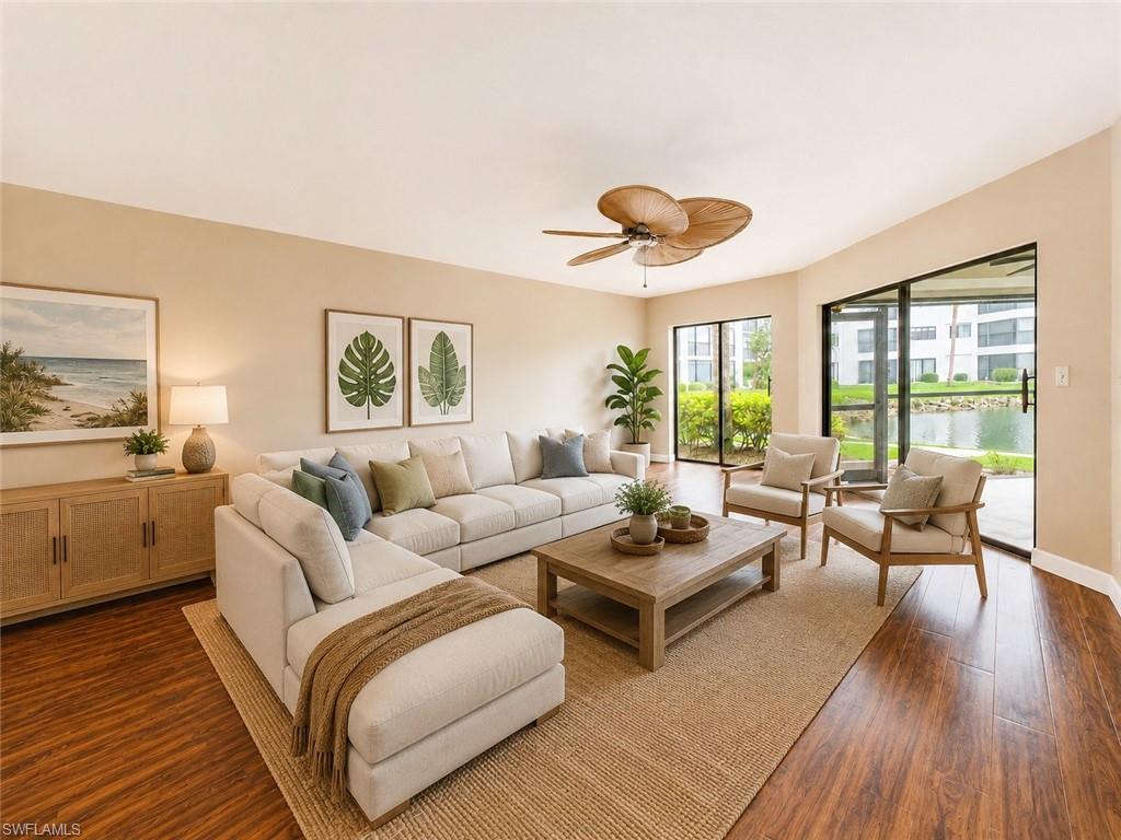 Expansive living area featuring wood-finish flooring, a ceiling fan, and multiple sliding glass doors