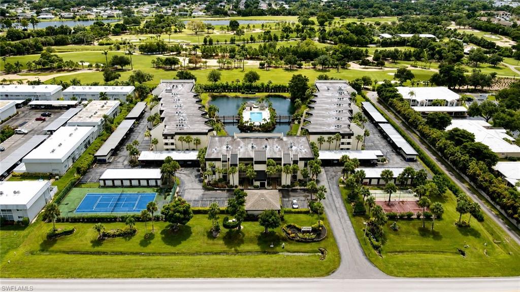 Aerial perspective of a multi-building complex featuring a central courtyard with a swimming pool and water feature