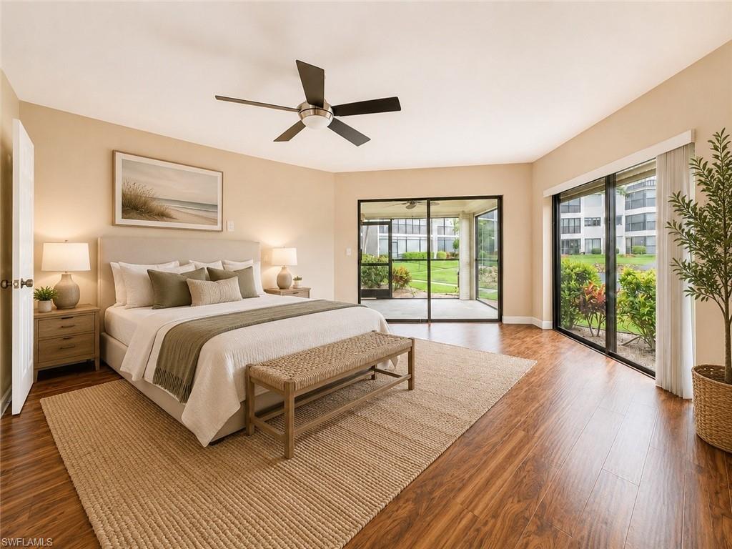 Spacious room featuring wood-finish flooring, a contemporary ceiling fan, and direct access to an enclosed lanai through sliding glass doors