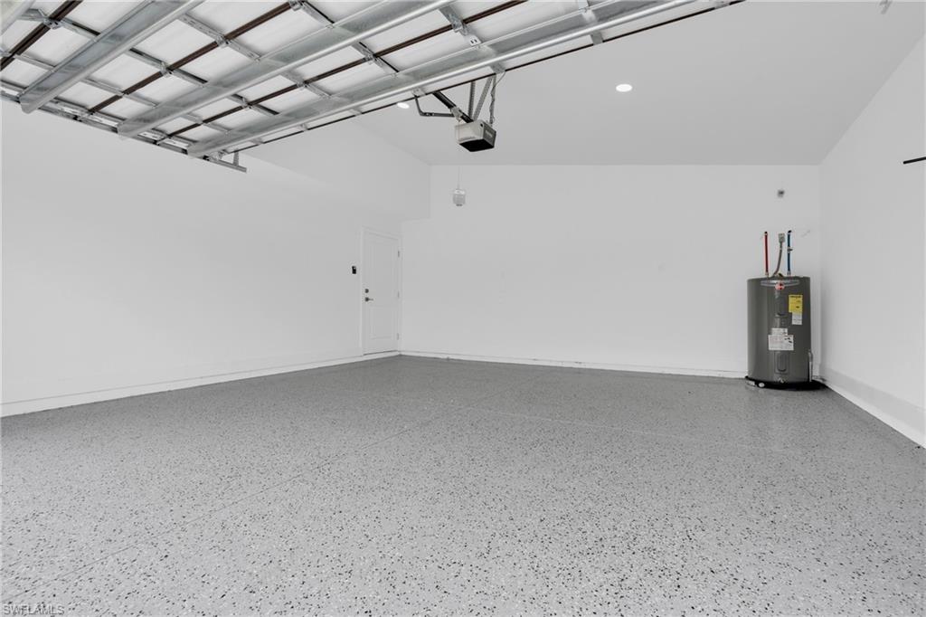 Garage featuring water heater and baseboards