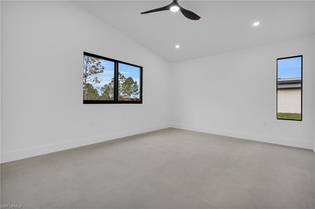 Unfurnished room featuring vaulted ceiling, recessed lighting, concrete floors, and a ceiling fan